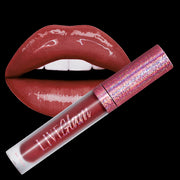 A sample bottle of the Bell Bottom Babe gloss liquid lippie, in front of a pair of lips with the gloss applied