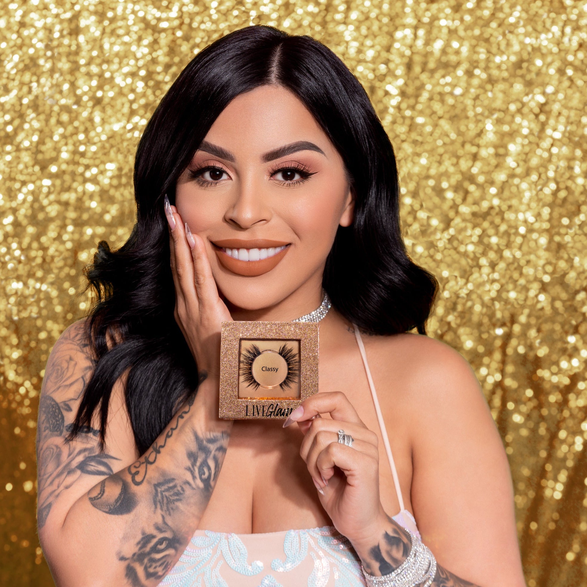 Our model holds up the Classy lashes as she stands in front of a glittery-gold backdrop