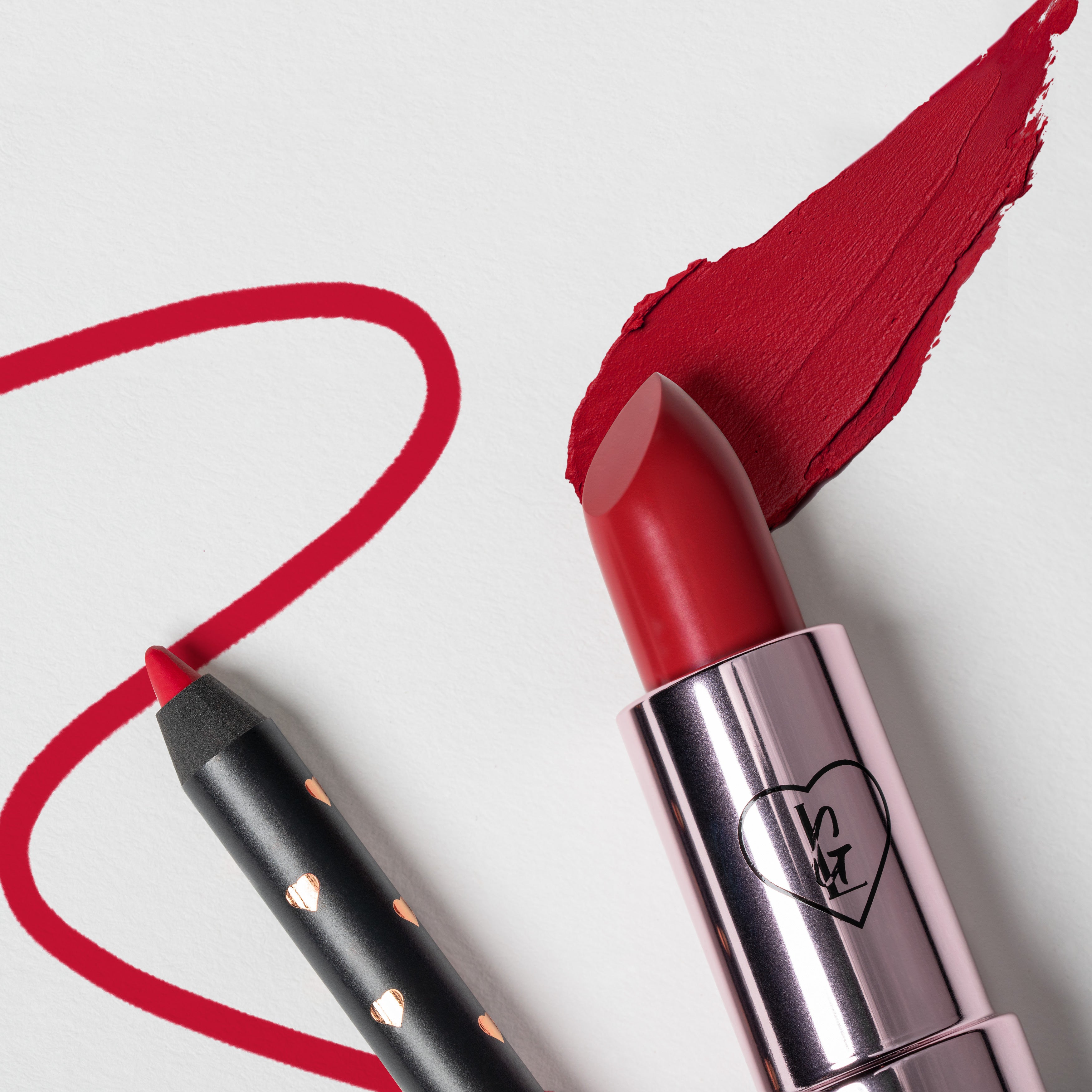 close-up of the tips of a red lip liner and red mami bullet, each with a swatch; on a white background