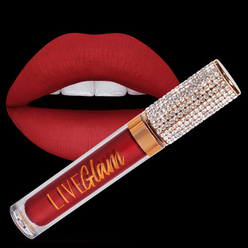 The red liquid lippie Kissmas with crystal-studded cap and gold-colored trim. It appears in front of a pair of lips with the shade Kissmas already applied to them. 