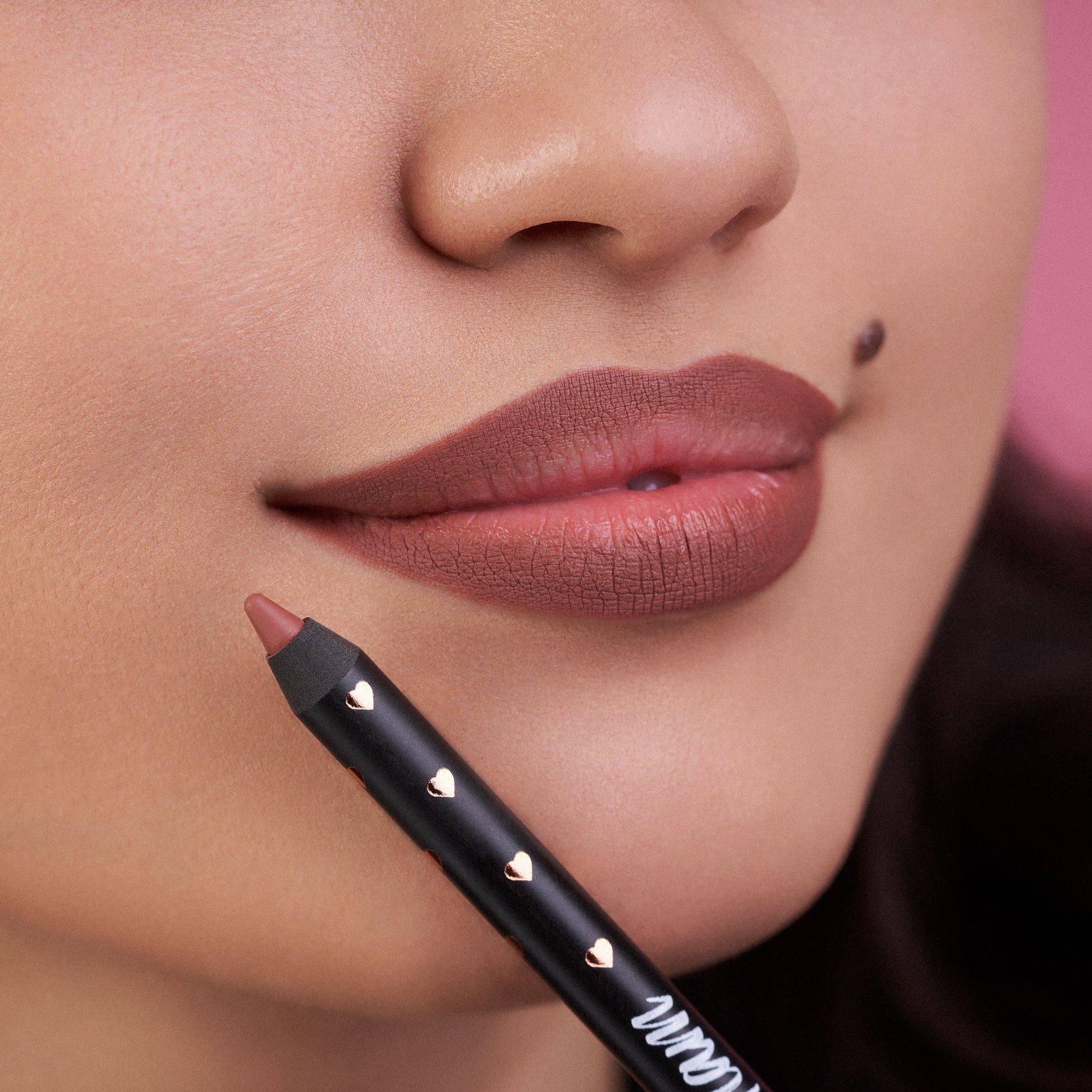 Close-up of a person holding the Lip Liner to her lips after having just applied it to her lips